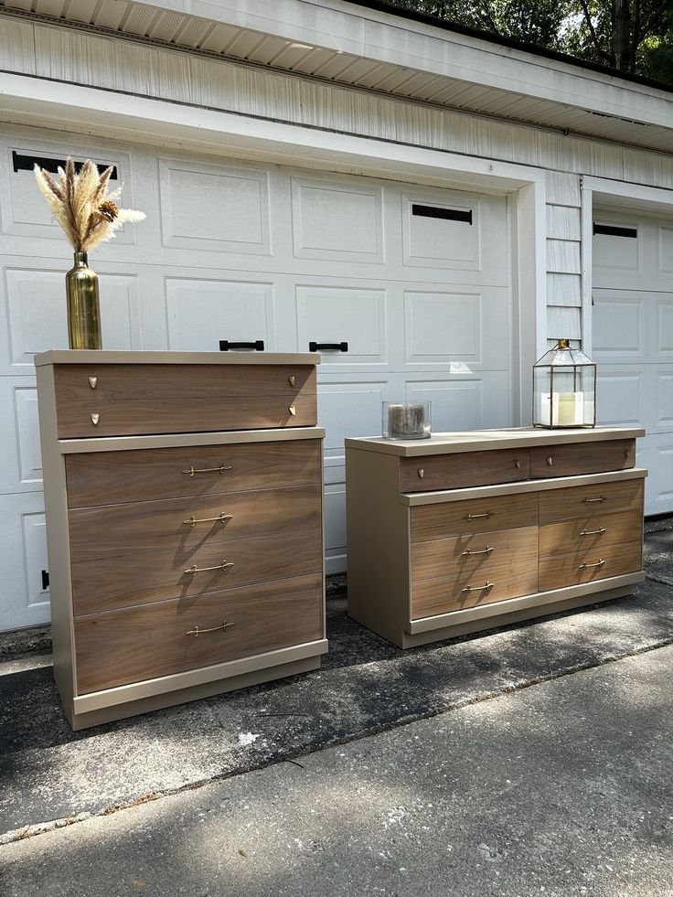 two wooden dressers sitting next to each other in front of a garage