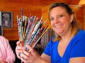 a woman holding a bunch of different colored pencils