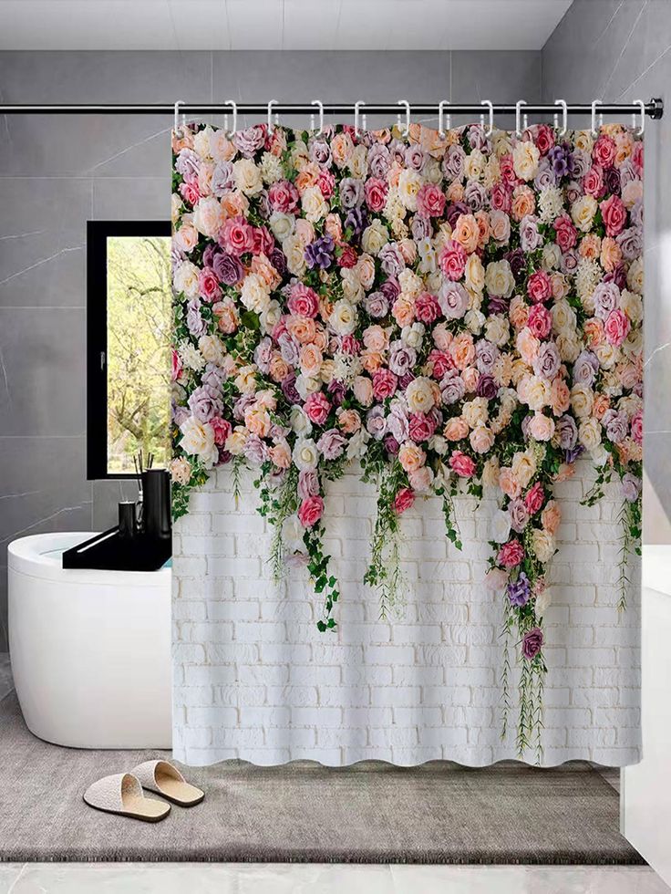 a shower curtain with pink and purple flowers on it next to a bathtub in a bathroom