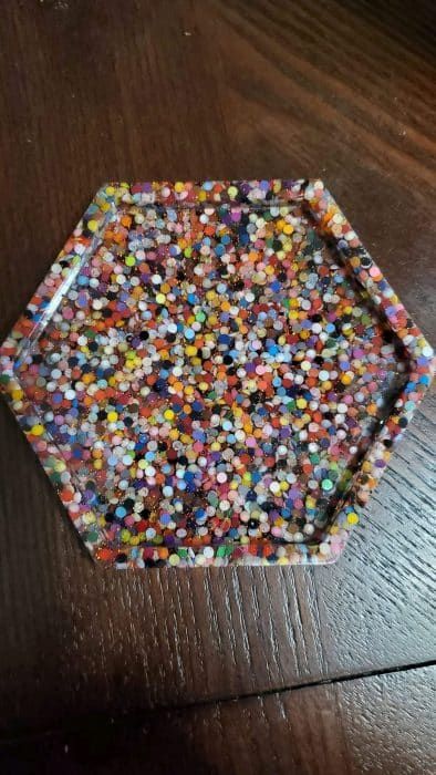 a wooden table topped with a plate covered in confetti sprinkles