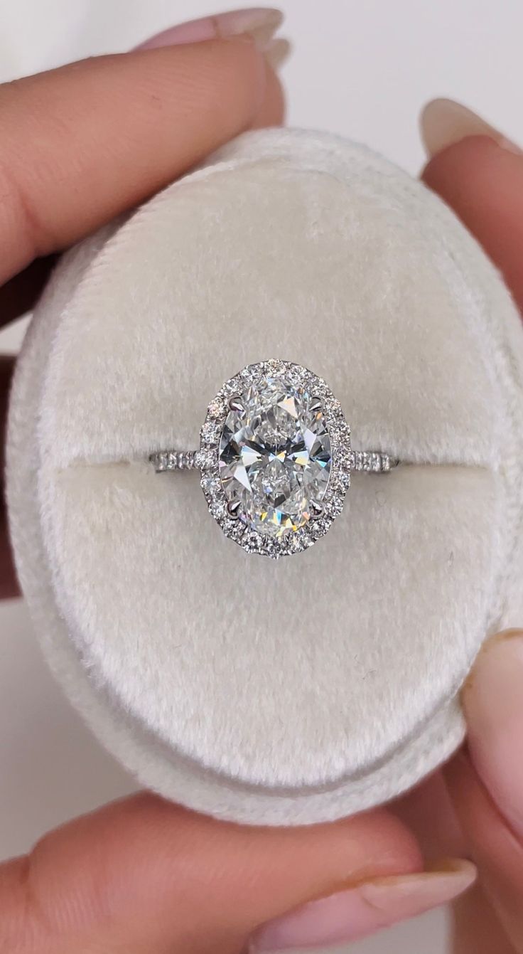 a diamond ring is being held in a white velvet case with the band around it