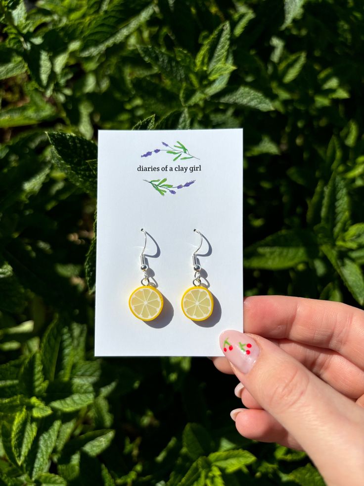 Now available in dangle drop (sterling silver as pictured) or huggies (surgical grade stainless steel).  Welcome to our listing for these delightful handmade mini lemon slice earrings! If you're searching for a splash of freshness and creativity to adorn your ears, these vibrant lemon earrings are just the accessory you've been looking for. Each of these earrings is meticulously crafted by hand, ensuring a one-of-a-kind and charming design that will brighten up any outfit. The intricate workmans Trendy Tiny Sterling Silver Earrings, Minimalist Earrings As Summer Gift, Minimalist Earrings For Summer Gift, Yellow Sterling Silver Single Earring, Yellow Jewelry For Summer Gifts, Sterling Silver Earrings For Everyday Summer Wear, Minimalist Sterling Silver Earrings For Summer, Yellow Summer Jewelry Gift, Novelty Hypoallergenic Jewelry For Everyday