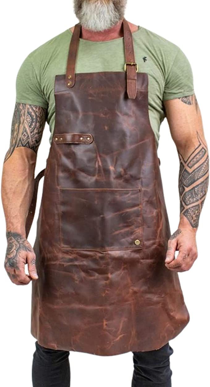 a man wearing an apron with tattoos on his arms