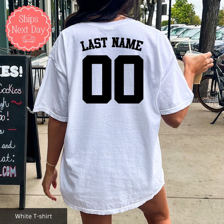 All of our sports number t-shirts are handmade to order on an ultra soft tee that will quickly become your go to apparel item! Our trendy sports shirts are printed using an eco-friendly water based ink that feels good and lasts longer!  🖤How to order🖤 *Select your size and style of garment *Select your color of garment. Please note: if the design has white ink in it do not order a white garment as it will not show up. If the design has black ink in it do not order a black garment as it will not show up. Let me know if you have questions on this! *ADD TO CART *Select from our shipping class options 🖤Sizing🖤 All our t-shirts are unisex sizing. For a more fitted look we recommend ordering your normal size. If you prefer your garment to be baggy / more oversized, then we recommend sizing u Sports Fan T-shirt For Baseball Season, Collegiate T-shirt With Name Print For Fans, Game Day Jersey T-shirt With Letter Print, Jersey T-shirt With Letter Print For Game Day, Collegiate White Sublimation Design With Name Print, Sports Fan T-shirt With Team Name For Baseball Season, Casual Crew Neck T-shirt For Football Season, Game Day Sports Fan T-shirt With Crew Neck, Sporty T-shirt With Text Print For Sports