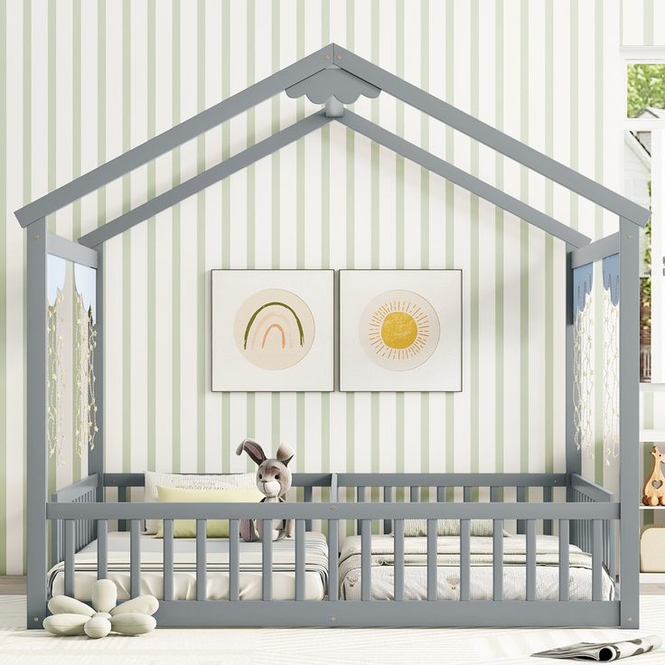 a baby crib with two pictures on the wall