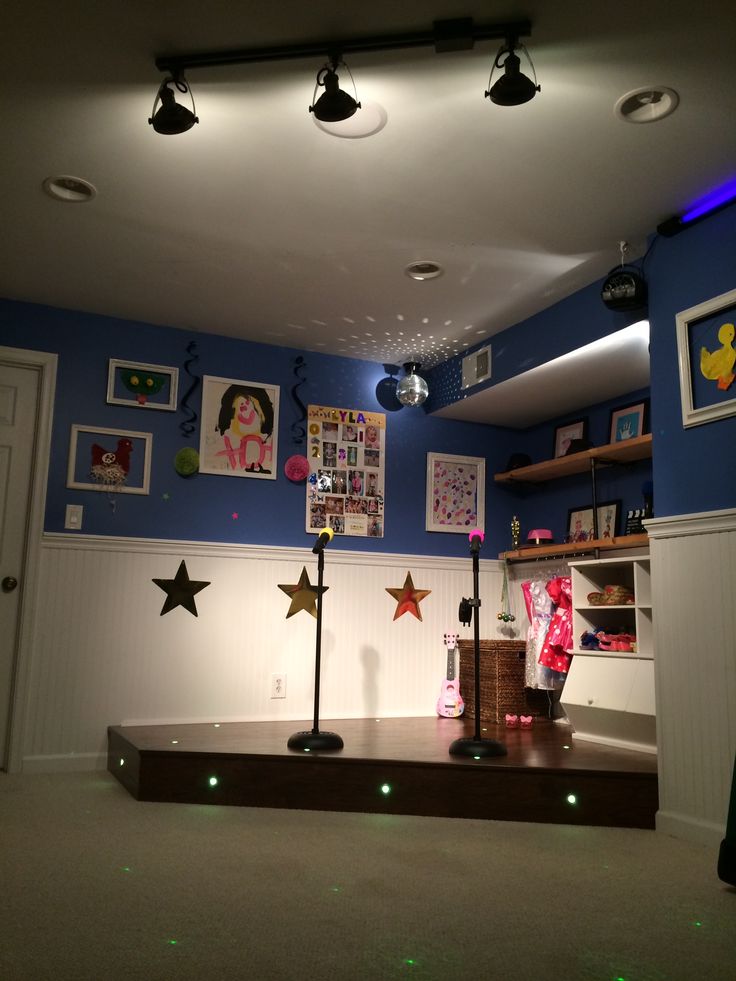 an empty room with blue walls and pictures on the wall, lights in the ceiling