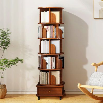 a tall wooden book shelf sitting next to a chair and potted plant in a living room