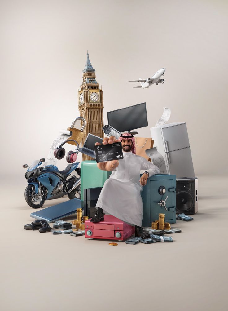 a man sitting on top of luggage in front of a pile of items and a clock tower