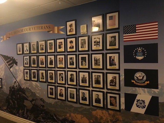 a wall with many pictures and flags on it