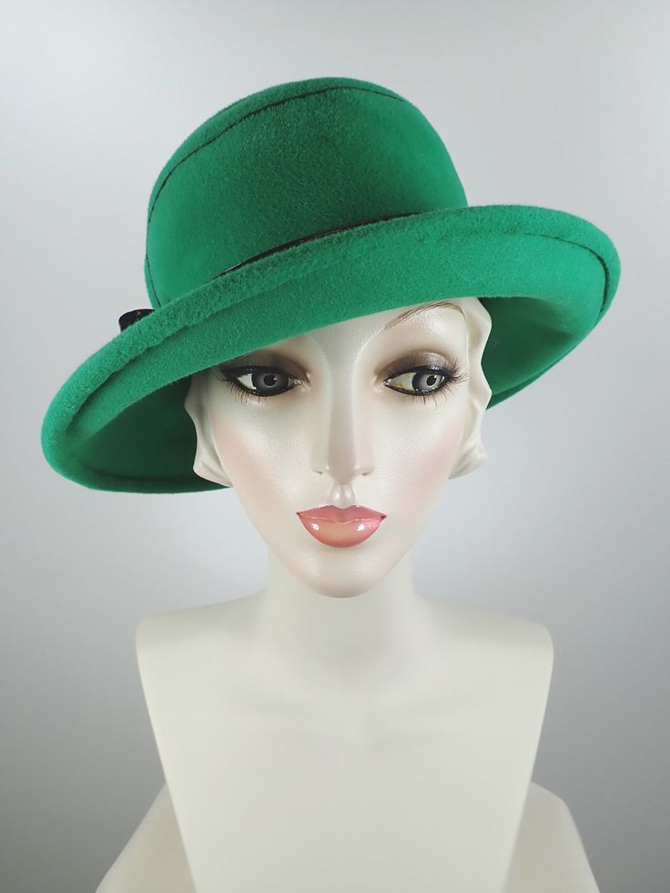 This pretty Kelly green medium brim hat is hand blocked over a vintage hat block and hand sewn. The asymmetrical brim rolls upward in the front and on the left side. Millinery wire is sewed inside of the brim edge to help the hat keep it's shape. The band is a gorgeous vintage patent leather with a matching bow. The top of the hat is hand embroidered in a swirl pattern in black cotton floss. An inner grosgrain headband helps avoid damage from makeup. Gorgeous in every way!+++++++++++++++++++++++ Green Hat Bands For Kentucky Derby, Retro Cloche Felt Hat For Winter, Green Fedora With Curved Brim For Spring, Kentucky Derby Wide Brim Fur Felt Top Hat, Retro Winter Cloche Felt Hat, Green Short Brim Fedora For Spring, Green Wide Brim Fedora For Spring, Adjustable Green Fedora Felt Hat, Adjustable Green Brimmed Boater Hat