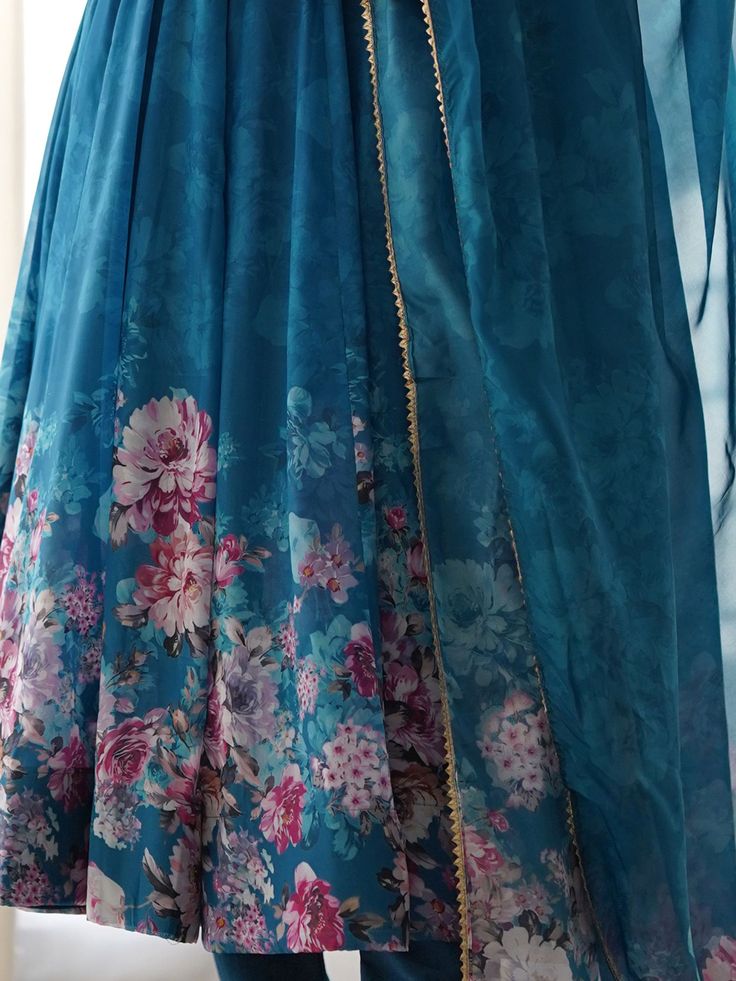 This beautiful blue color organza anarkali suit features intricate floral print work, making it a perfect choice for festivals, functions, and events. The set includes a matching cotton silk pant and a dupatta with floral print work and border gota patti lace work.
The anarkali suit has a 2.3-meter flair, and the dupatta is also 2.3-meters long.  This blue anarkali pantsuit include its fully stitched design, available in sizes XS to XXL, ensuring a perfect fit for everyone.
The vibrant blue Bollywood Style Georgette Anarkali Set With Digital Print, Bollywood Style Georgette Salwar Kameez With Digital Print, Bollywood Style Digital Print Floor-length Sharara, Bollywood Style Floor-length Digital Print Sharara, Floor-length Anarkali Set For Navratri With Digital Print, Bollywood Style Floor-length Digital Print Salwar Kameez, Bollywood Style Floor-length Salwar Kameez With Digital Print, Blue Dupatta With Printed Border For Diwali, Festive Blue Dupatta With Printed Border