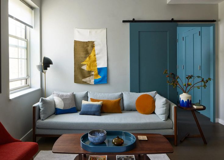 a living room filled with furniture and a painting on the wall