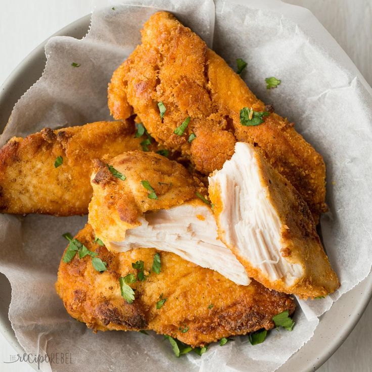 fried chicken with parsley on top in a bowl