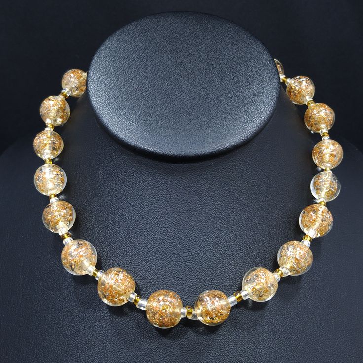 *Description: This is a beautiful clear Murano Italian glass beaded necklace made in the 1930s and filled with flecks of copper & gold which looks like glitter. Gold and copper within the beads is referred to as Aventurine. The necklace was designed with 20 12mm beads separated by clear and gold seed beads. There are six 8mm beads which are wire wrapped to add a matching extension chain. These are gorgeous Venetian beads and as a bead collector, these are one of my favorites. It is a beautif Vintage Gold Polished Beads, Vintage Polished Gold Beads, Vintage Clear Round Necklace, Vintage Clear Round Bead Necklaces, Vintage Clear Glass Necklaces, Vintage Clear Glass Necklace, Antique Gold Necklace With Large Beads, Formal Glass Beaded Necklace, Vintage Glass Spacer Beads Jewelry