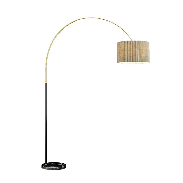 a black and gold floor lamp with a beige shade on it's side, against a white background