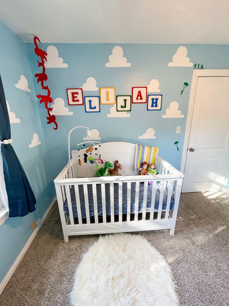 a baby's room with blue walls and clouds on the wall