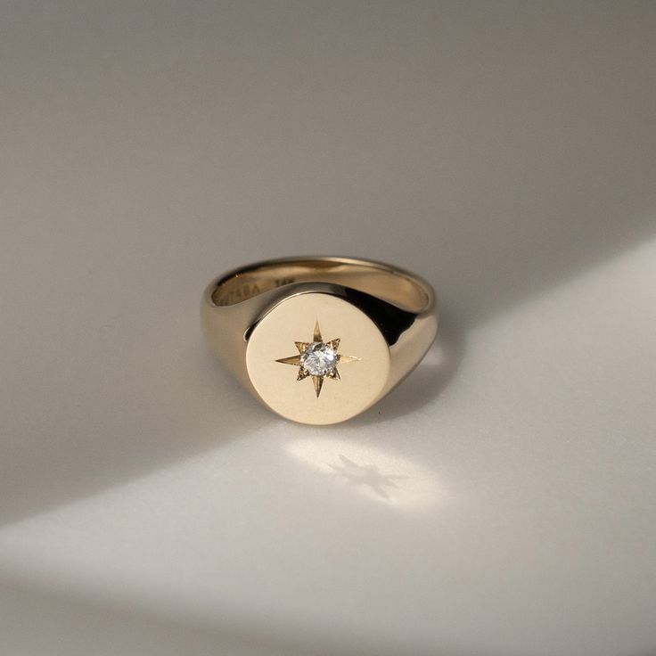 Our modern take on the classic heirloom signet ring. North Star symbolizes inspiration and hope. It guide you through the dark night, navigate towards your destination. Round face signet ring with a white diamond set into traditional starburst engraving. Made to order: Please allow 4 weeks production time as each piece is created just for you. Made with recycled 14K Yellow Gold Round face diameter = 10mm 2.5mm White Diamond total Carat weight 0.03 ct. Handmade in NYC Classic Star-shaped Signet Ring With Polished Finish, Classic Star Shaped Signet Ring With Polished Finish, Classic 14k Gold Star Shaped Signet Ring, Classic Polished Star Shaped Signet Ring, Elegant 14k Gold Star-shaped Signet Ring, 14k Gold Star Shaped Signet Ring With Polished Finish, Celestial Signet Ring With Polished Finish For Anniversary, Celestial Style Signet Ring For Anniversary, Pinky Signet Ring