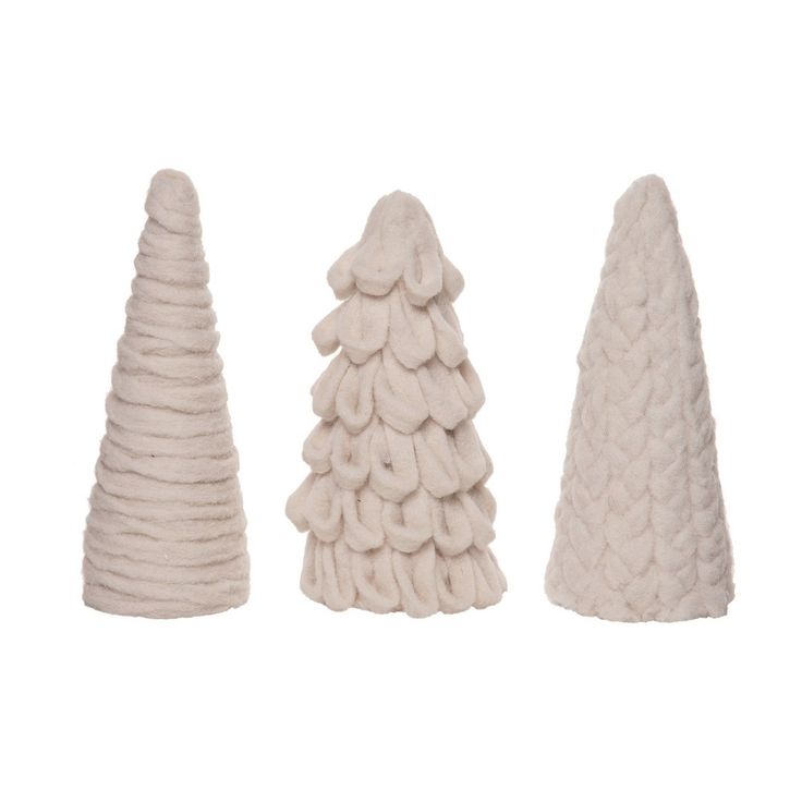 three white knitted christmas trees on a white background