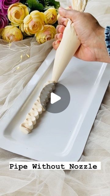 a person using a knife to cut something on a plate with flowers in the background