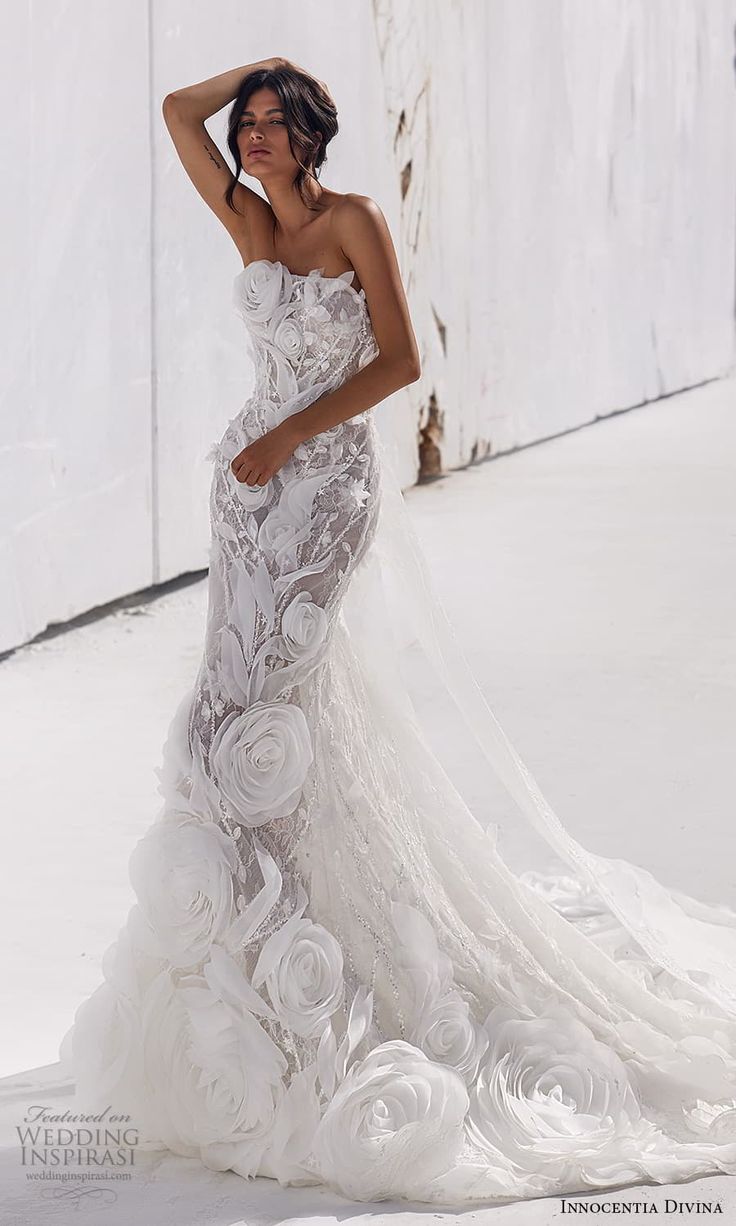 a woman in a wedding dress posing for the camera with her hand on her head