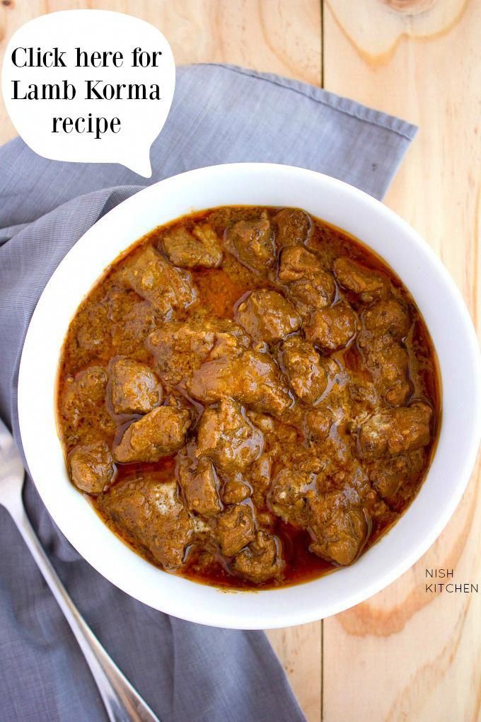 a bowl filled with meat and sauce on top of a blue napkin next to a fork