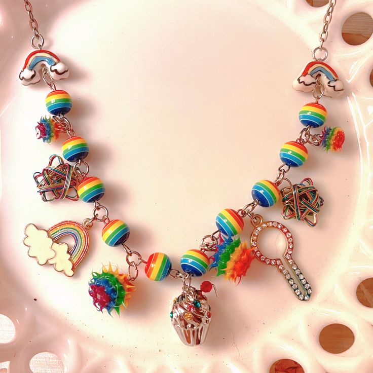 "Beaded chain made with plastic rainbow beads, adorned with upcycled, rescued charms from broken jewelry, all with a \"rainbow\" theme. Perfect for Pride or any rainbow fan! One of a kind piece!! 🌈🏳️🌈 Because of the upcycled nature of the pieces of this necklace, I cannot guarantee that this necklace is 100% allergy free. That being said, all of the findings are nickel free.  Due to the handmade nature of my items, please handle them with care and refrain from getting them wet or pulling/tugging on them." Whimsical Rainbow Dangle Jewelry, Rainbow Fan, Vintage Wreath, Shatterproof Ornaments, Rainbow Theme, Neon Rainbow, Assemblage Jewelry, Rainbow Beads, Allergy Free