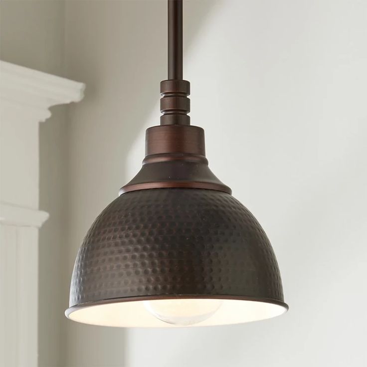 a light fixture hanging from the ceiling in a room with white walls and wood trimmings