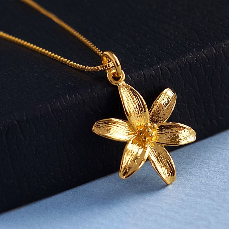 "Gold Lily Flower Pendant Necklace, 24k Gold Vermeil Style Lily and Gold Filled Chain, Mothers Day Jewelry Gift, Anniversary Necklace, FREE SHIPPING This high polished Vermeil style 24 karat gold lily pendant has an elegant and detailed floral design. The lily pendant can be matched with your choice of 14 karat gold filled chain. What is Vermeil Style? Gold vermeil jewelry refers to gold plated over 925 sterling silver. To be considered Vermeil the gold layer must be at least 2.5 microns thick.  Gold plated jewelry has a thin gold layer of at least 0.5 microns over an inexpensive base metal such as copper or brass. Like gold vermeil jewelry, vermeil style jewelry is layered over 925 sterling silver. Vermeil style also has twice the thickness of gold layer (1.0 micron) than gold plated jewe Lily Flower Jewelry, Lily Flower Necklace, Gold Flower Necklace For Anniversary, Gold Flower Pendant Necklace Gift For Her, Gold Flower Pendant Necklace For Anniversary, Gold Flower Necklace As Gift For Her, Gold Flower Necklace For Her, Gold Flower Necklace Gift For Her, Gold Flower Pendant Necklace For Mother's Day