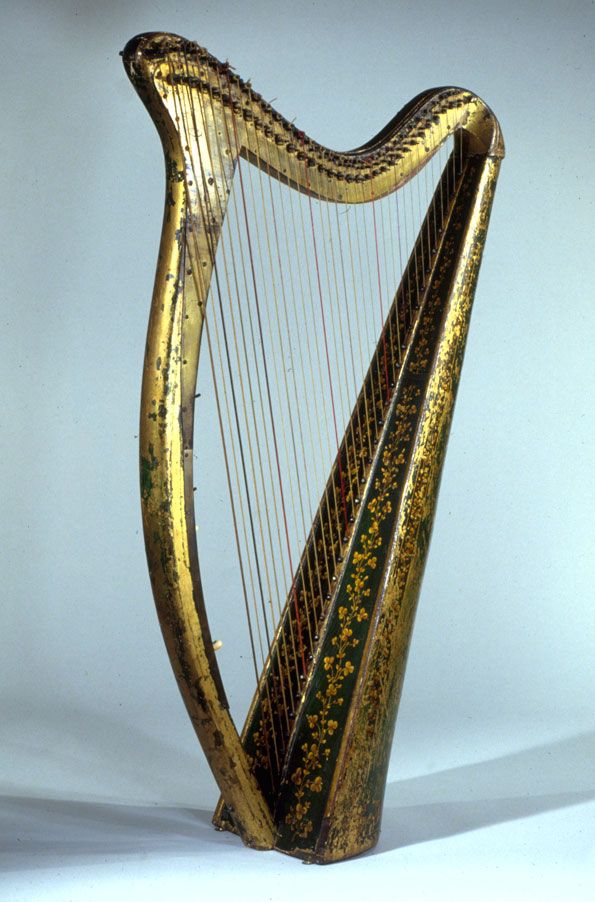 an ornate gold colored harp on a white background