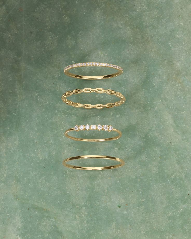 three different types of rings sitting on top of a green surface with one ring in the middle