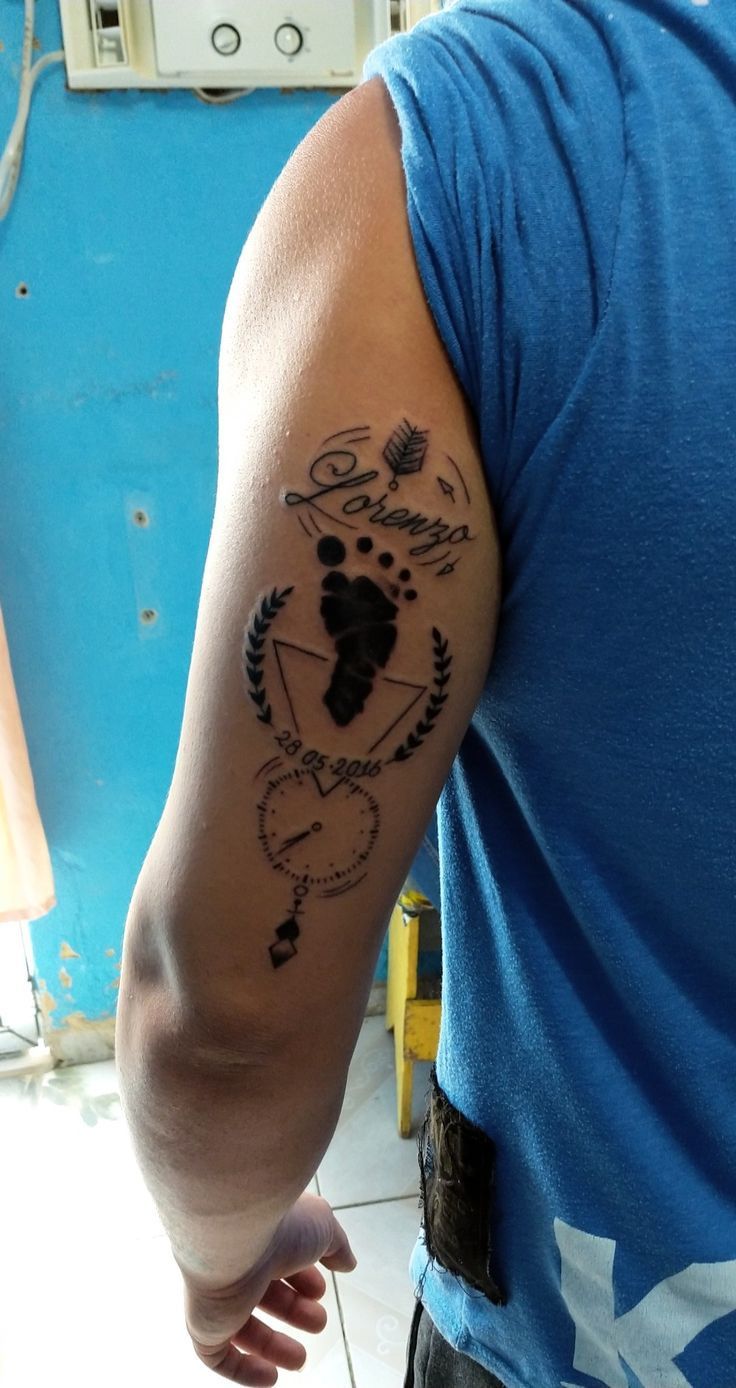 a man with a tattoo on his arm that has an arrow and compass in it