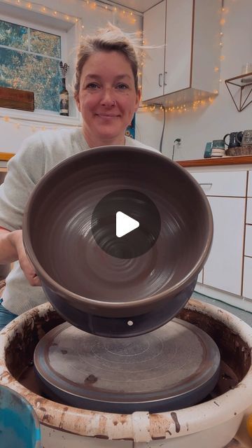 a woman sitting in front of a large bowl