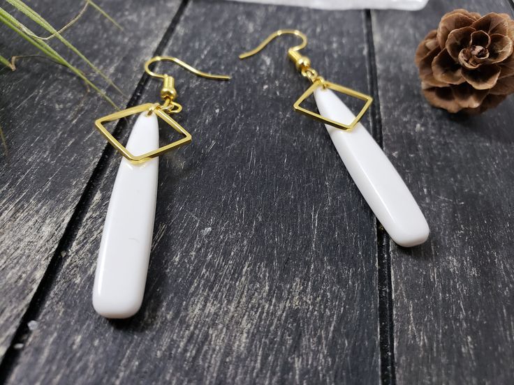 "These long white and gold drop earrings feature 39mm flat white acrylic teardrop beads, overlaid at the top with 12mm gold-plated brass open square links. These lightweight earrings transition effortlessly from office wear to street wear, and are lightweight enough to wear all day. These white drop earrings measure 2.5 inches from the bottom of the teardrop to the top of the ear wires, which are made of hypoallergenic gold-plated surgical steel. Domestic shipping is always free here at MayaMade White Drop Linear Earrings, White Teardrop Earrings As Gift, White Minimalist Teardrop Dangle Earrings, Modern White Teardrop Linear Earrings, Minimalist White Teardrop Earrings, White Drop Earrings For Gift, White Drop Earrings Gift, Handmade White Teardrop Dangle Earrings, Hypoallergenic White Dangle Earrings