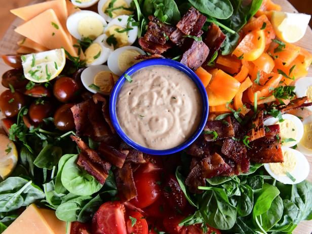 a platter filled with lots of different types of vegetables and dip in the middle