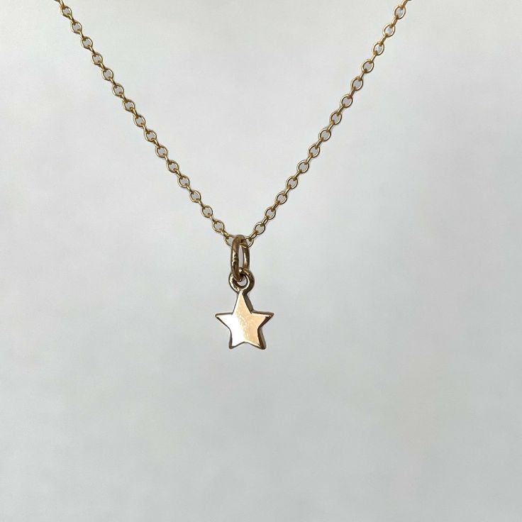 I love stars and this Gold Star Necklace is a charmer. Stars celebrate accomplishments, promote inner confidence to be your best, and are reminders of beautiful starry nights. This dainty mini star can be on a 16 inch or 18 inch 14K gold filled chain. Bronze star measures 1/4” wide and hangs 1/2” from chain 14K gold filled chain is 16 inch or 18 inch, Lead and Nickel Free. Assembled in our studio in Portland, OR Dainty 14k Gold Filled Star Charm Necklaces, Dainty Yellow Gold Star Charm Necklace, Dainty 14k Gold Filled Star Charm Necklace, Delicate Yellow Gold Charm Necklace With Star Charm, Delicate Yellow Gold Star Charm Necklace, Dainty Star Charm Necklaces, Dainty Star-shaped Charm Necklace, Dainty Star Charm Necklace, Delicate Star Charm Necklace For Gift