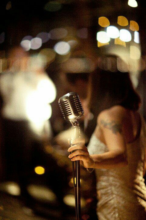 a woman holding a microphone in her hand