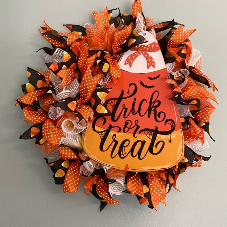 a halloween wreath that says trick or treat on the front and side with an orange pumpkin