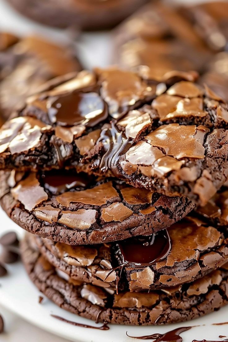 chocolate cookies are stacked on top of each other and drizzled with melted chocolate