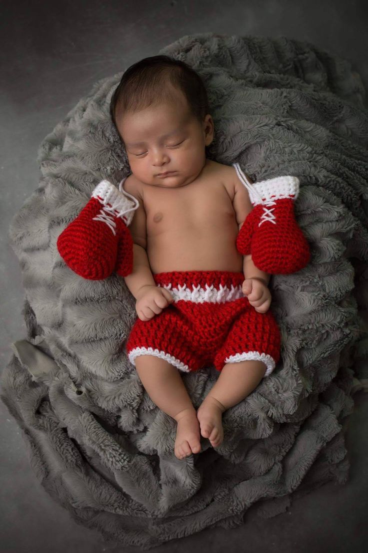 a newborn baby wearing red and white crocheted clothing