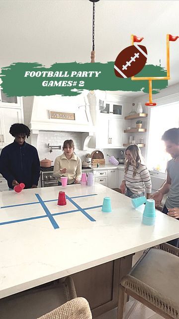 a group of people standing around a table with cups on it and a football party game in the background