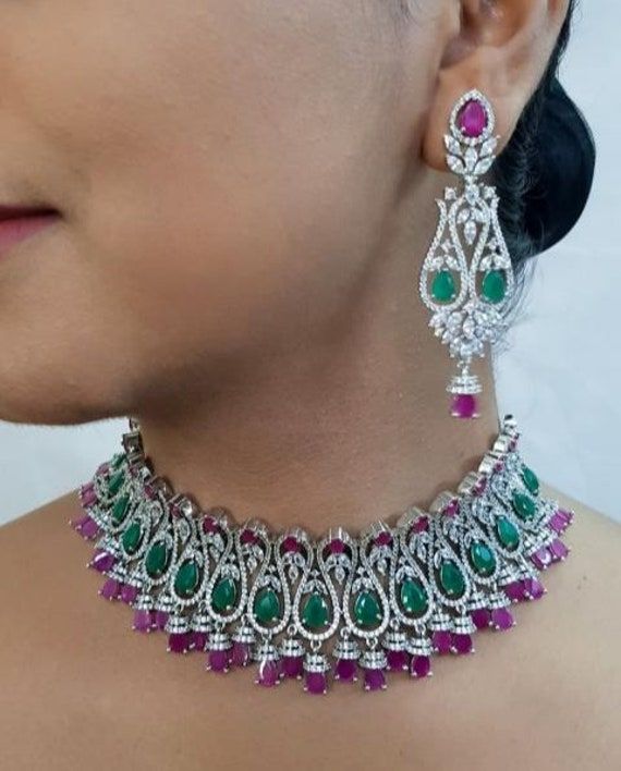 This wedding season you are looking outstanding when you wear this classy American Diamond (Cz stone) Statement Necklace Set. Easy to wear, light in weight & gives you a rich look. A Necklace that will make you feel royal. Jewellery made from American diamonds has been favourite of women for decades and still hold their graceful charm. American diamond necklace comes with beautiful and attractive matching earrings. Guaranteed to transform your look in seconds to gain instant luxury, this stunnin Dazzling Necklaces With Sparkling Stones For Reception, Diamond Bridal Necklace With Stone Work For Parties, Jeweled Round Bridal Necklace For Party, Cubic Zirconia Necklace With Sparkling Stones For Receptions, Jeweled Bridal Necklace For Party, Wedding Jewelry With Sparkling American Diamonds, Traditional Bridal Necklace With Jewels And Cubic Zirconia, Elegant Bridal Necklace With Stone Work In Cubic Zirconia, Dazzling Bridal Necklace With American Diamond For Parties