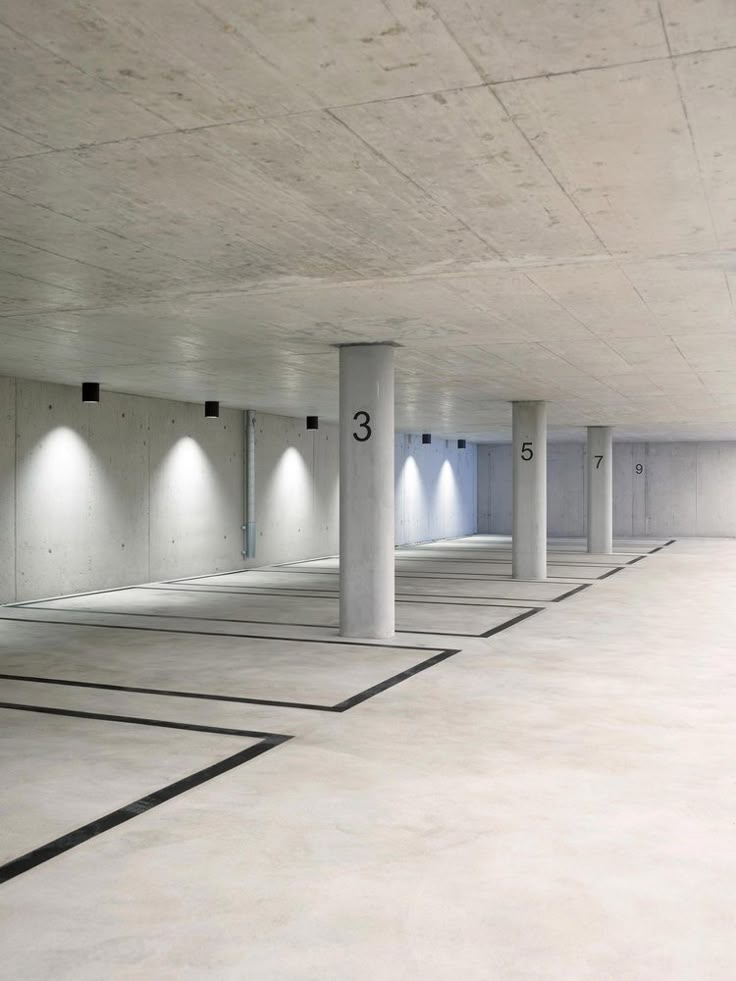 an empty parking garage with several lights on the ceiling and no one in the area