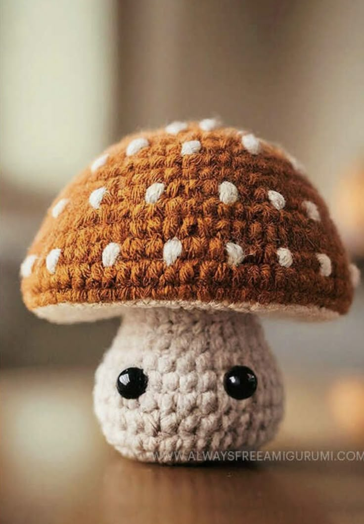 a small crocheted mushroom sitting on top of a wooden table