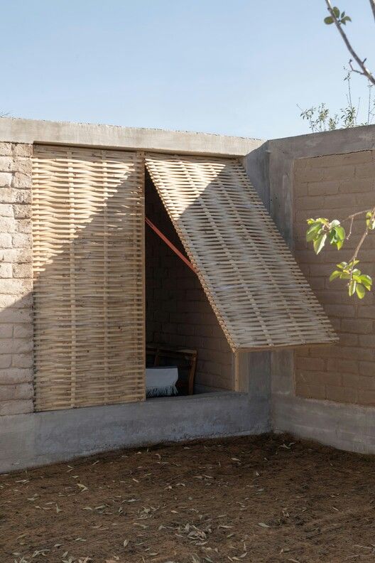 a building made out of bricks with a wooden structure on the outside and an open door at the top