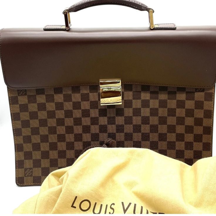 Up for sale is a stunning vintage Louis Vuitton Damier Ebene Altona PM Briefcase. This unisex piece is brand new and has the tags inside the interior Pocket. This classic piece comes in a rich brown color with a gold buckle closure. The briefcase is made of high-quality leather and features the iconic Louis Vuitton brand, making it a must-have for any fashion enthusiast. This briefcase model is part of the Louis Vuitton Damier product line and has a retail price of $3200. It's perfect for both m Important Documents, Fashion Enthusiast, Louis Vuitton Damier Ebene, Damier Ebene, Vintage Louis Vuitton, High Quality Leather, Timeless Pieces, Louis Vuitton Damier, Brown Color