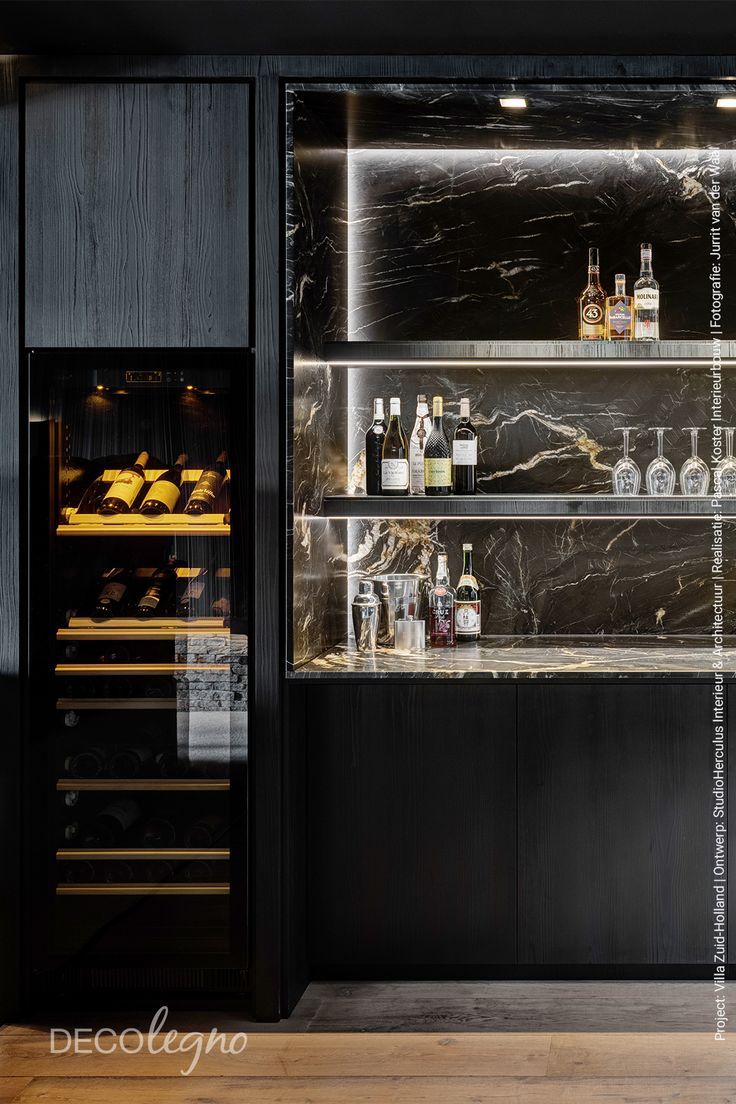 an empty wine cellar with bottles and glasses on the shelves in black marbled wood