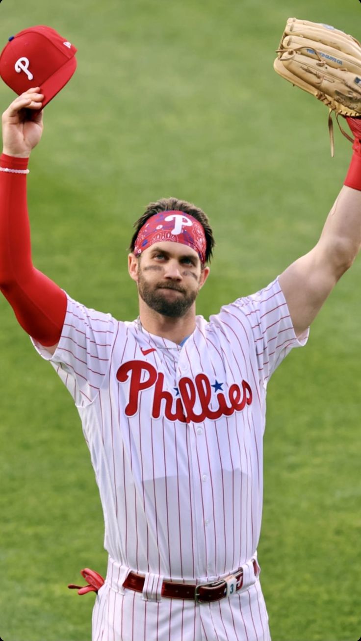 a baseball player is holding his glove up in the air while wearing a red bandana