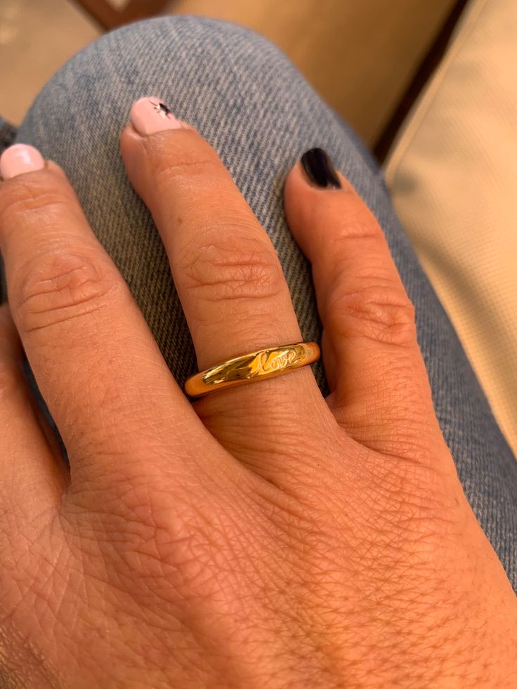 a woman's hand with a gold ring on it