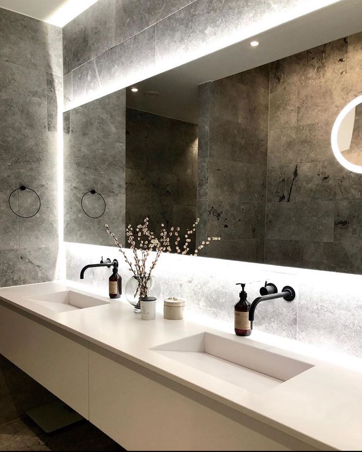 a bathroom with two sinks and a large mirror above it's countertop area