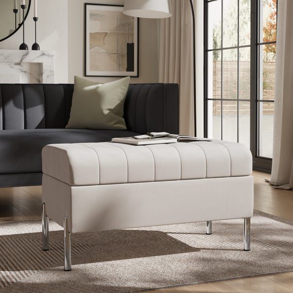 a white bench sitting on top of a hard wood floor next to a couch in a living room